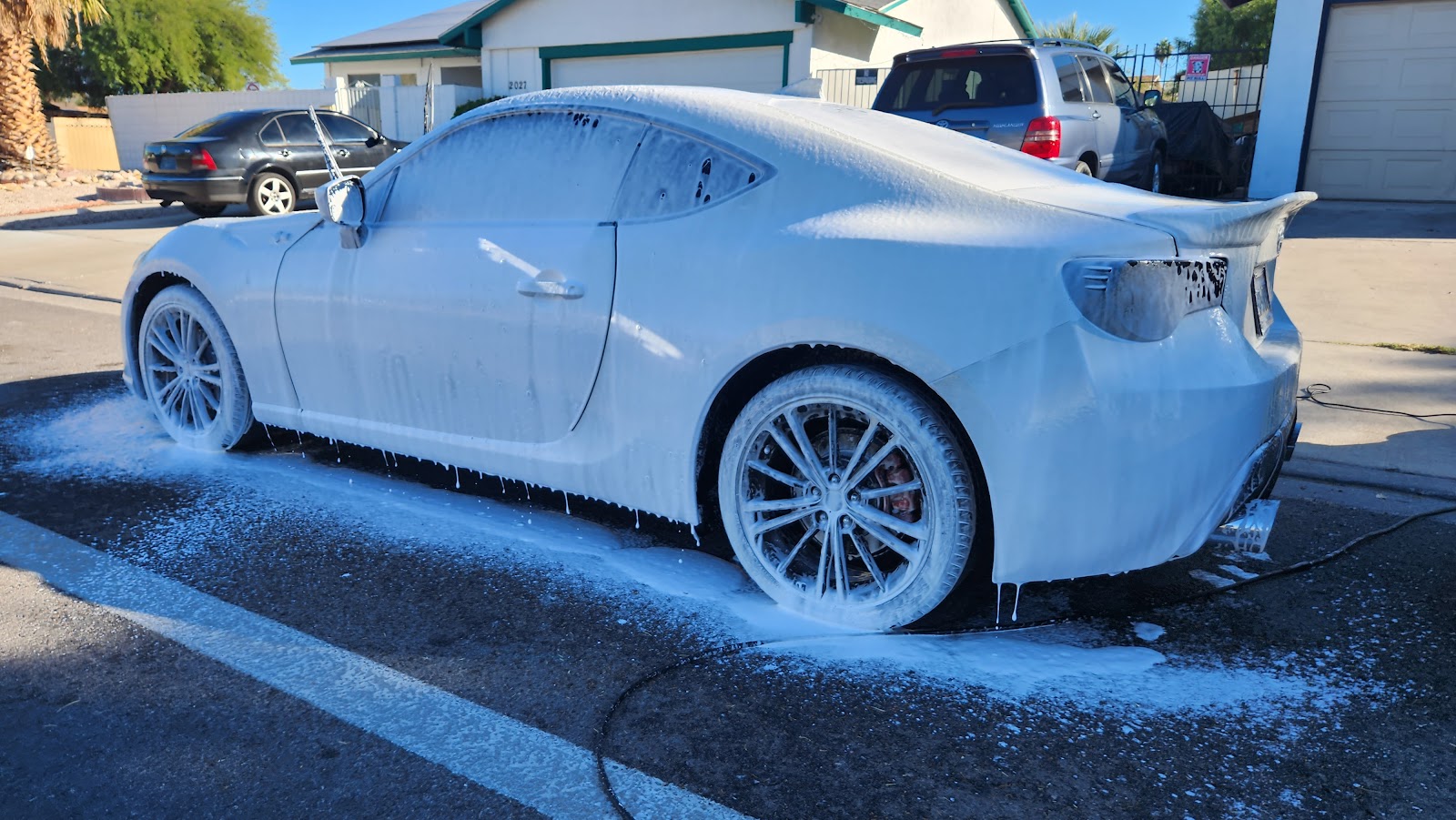 Sports coupe covered in foam soap during a wash